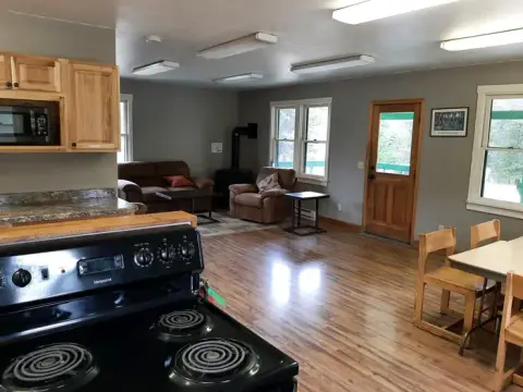 An interior view of a room with a kitchen area, living space, and dining table.