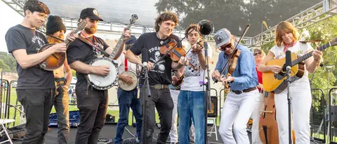 A band playing bluegrass music on an outdoor stage.