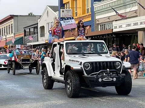 A parade featuring people riding in vehicles on a street.