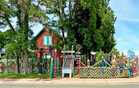 A colorful decorated house and yard behind a fence.