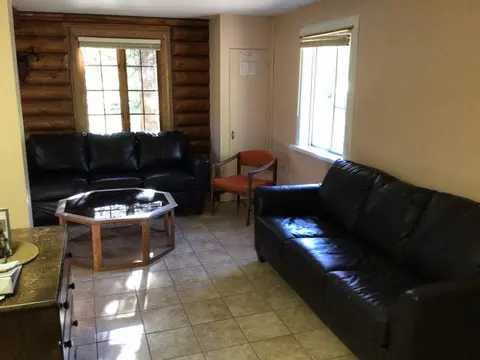 An interior shot of a room with two dark leather sofas and a coffee table.