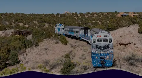 A train travels through a sparse desert landscape.