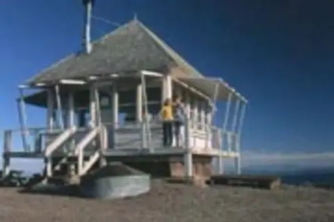 A small building stands atop a mountain.