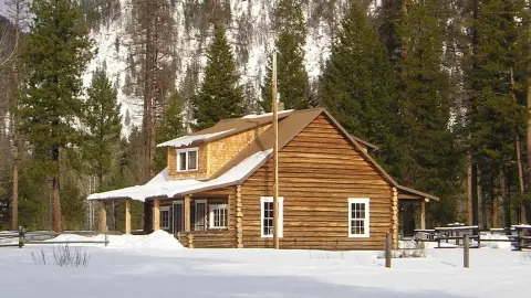 A log cabin in a snowy forest.