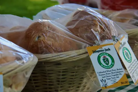 A basket filled with loaves of bread wrapped in plastic with a label attached.