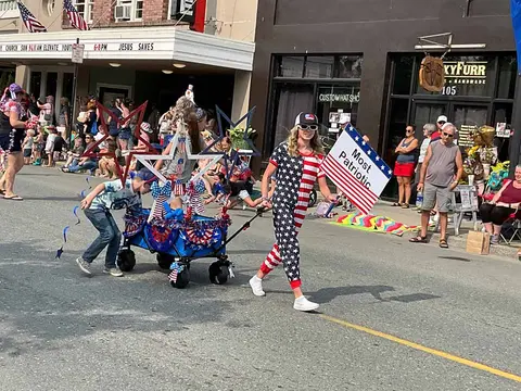 People participate in a patriotic parade on a town street.