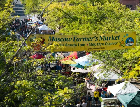An outdoor market with tents and a large banner.