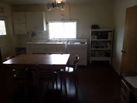 An interior view of a simple kitchen and dining area.