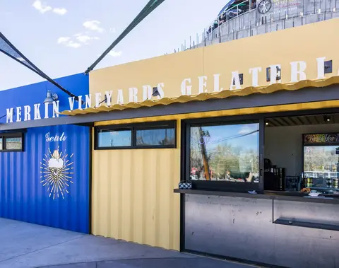 A photograph showing the exterior of a brightly colored shop with a sign.