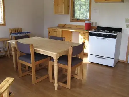 An interior shot of a kitchen and dining area with wooden furniture.