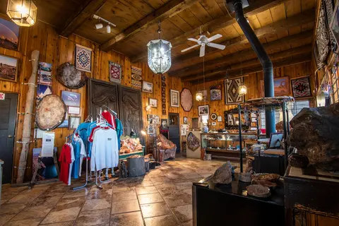 Interior view of a rustic wooden shop with merchandise and displays.