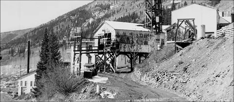 Black and white photograph showing historic industrial buildings on a hillside.