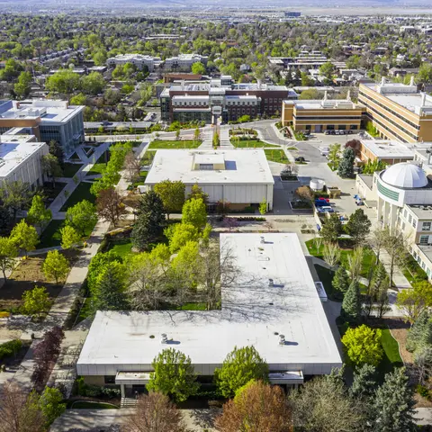 An aerial view shows buildings and trees on a university campus.
