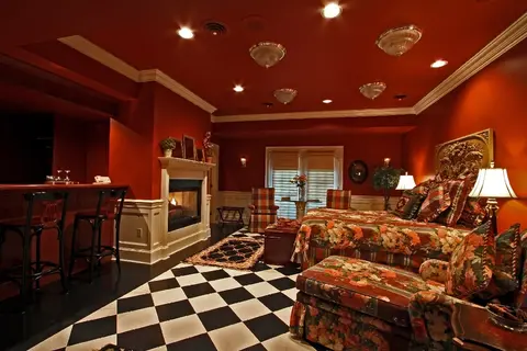 An interior bedroom with red walls and a black and white checkered floor.