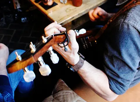 A person playing a guitar indoors.