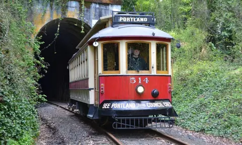 A vintage trolley emerges from a tunnel.