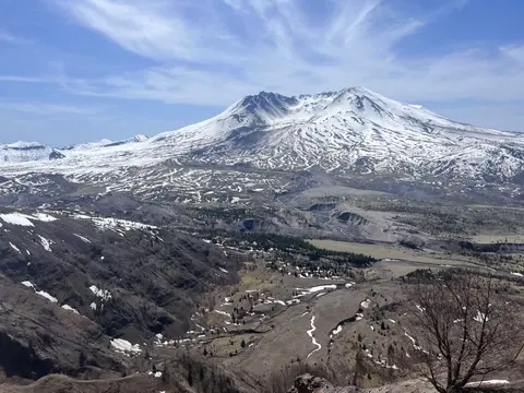 A snow-covered volcano mountain with a large crater and a valley below.