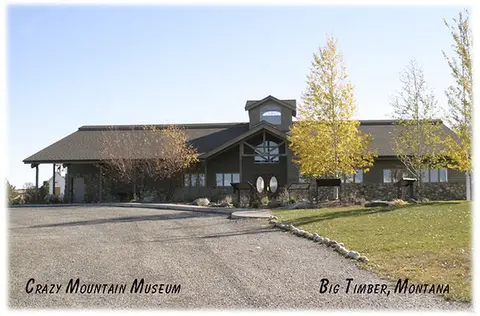 An exterior view of a building with a gravel driveway in front.