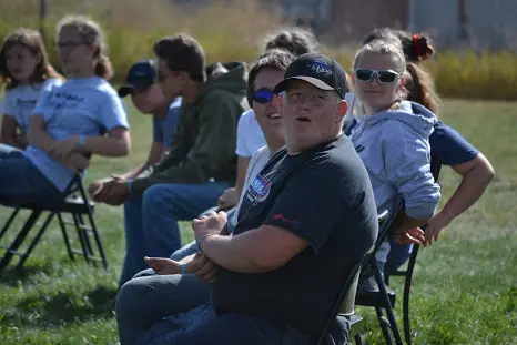 A group of people sitting on chairs outdoors.