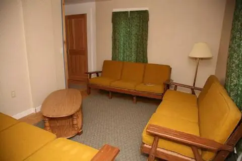 A living room interior furnished with yellow sofas and a coffee table.