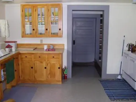 An interior view of a kitchen with wooden cabinets and a doorway.