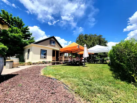 A building with outdoor seating under canopies on a sunny day.