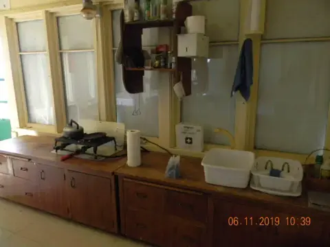 An indoor view of a rustic kitchen with wooden counters and windows.