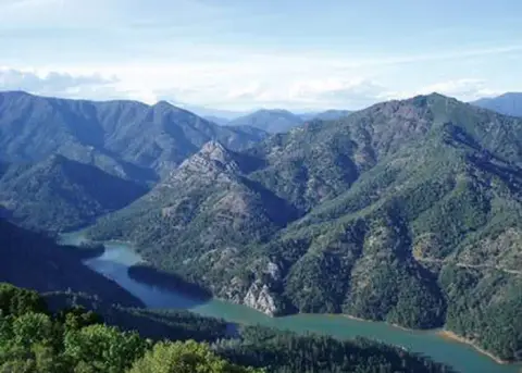 A river winds through green mountains.