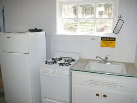 A small kitchen featuring a refrigerator, stove, and sink.