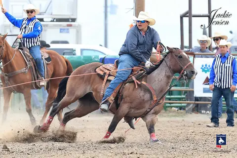 A cowboy rides a horse during a rodeo event.