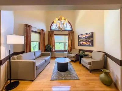 A well-lit hotel lobby or sitting room with a sofa and armchairs.