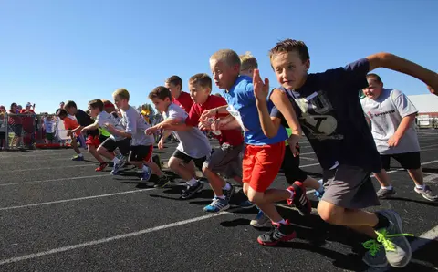 A group of children begin a race on a running track.