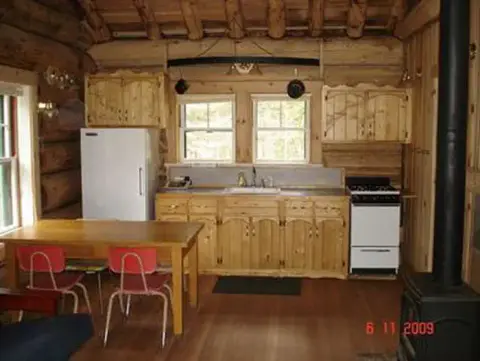 The interior of a rustic log cabin kitchen.
