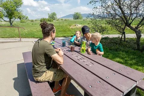 A family eating at a picnic table outdoors.