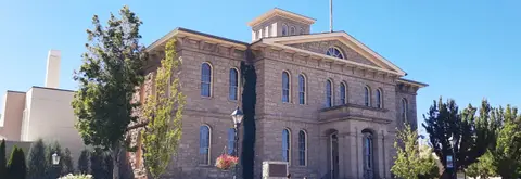 An exterior view of a historic stone building under a clear blue sky.