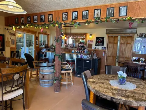 An interior shot of a rustic restaurant with wooden accents and a bar.