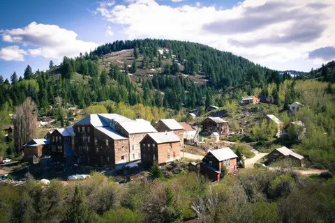 A view of historic wooden buildings nestled in a mountain valley.