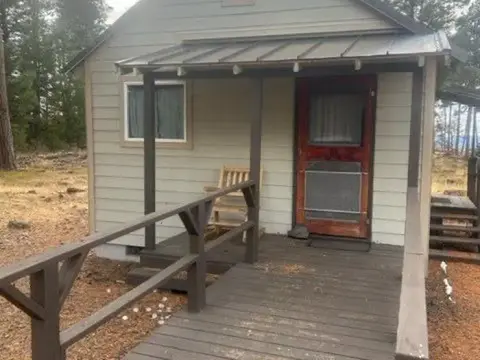A small cabin with a wooden porch and ramp.