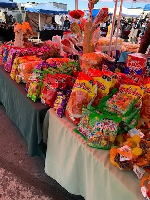 A market table displays an assortment of snacks and candies.