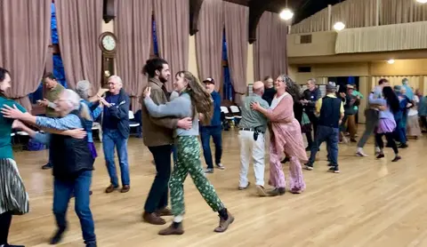 A group of people dancing in a hall.