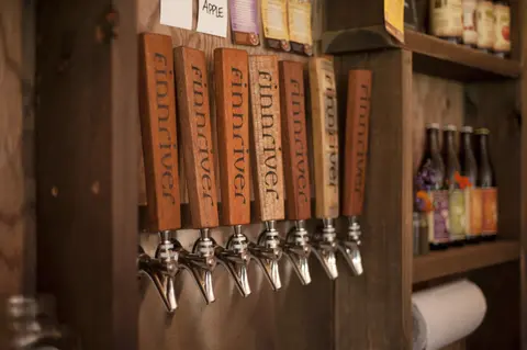 A row of wooden tap handles inside a rustic establishment.