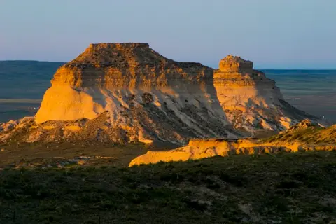 A landscape view of rocky bluffs under a clear sky.