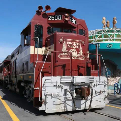 A brown and white locomotive sits on tracks.