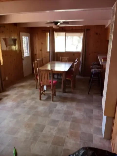 An interior shot of a dining room with wood-paneled walls and a tiled floor.