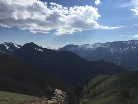 A scenic view of a mountain range under a partly cloudy sky.