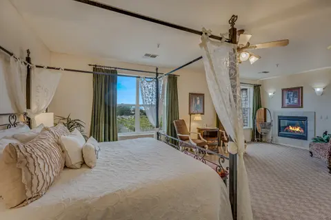 A large bedroom with a canopy bed and fireplace.