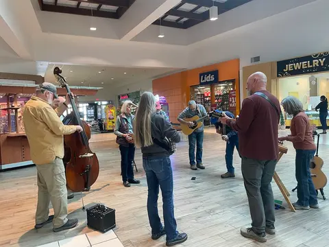 A group of musicians playing instruments inside a shopping mall.