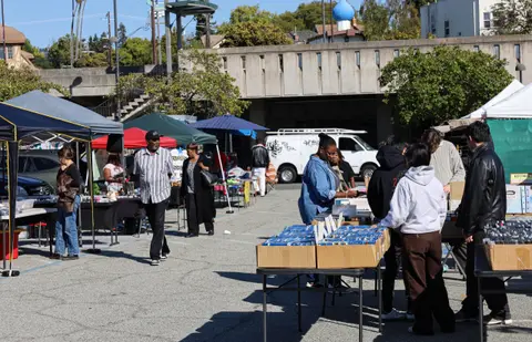 People browsing stalls at an outdoor flea market.