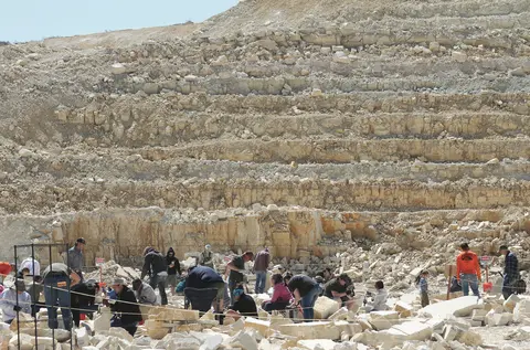 People digging and working in a rocky quarry.