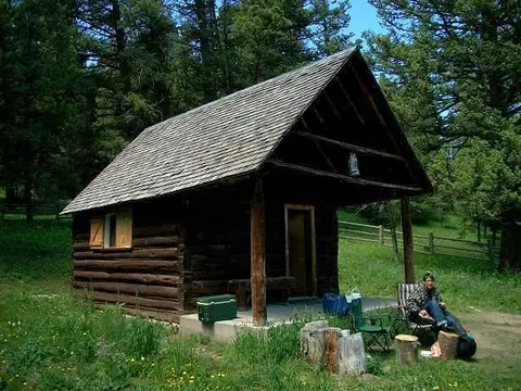 A rustic wooden cabin nestled in a clearing surrounded by trees.